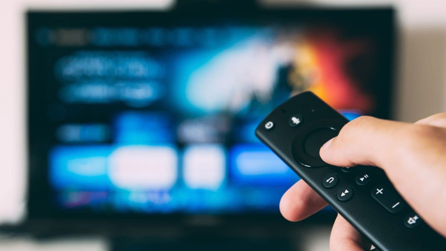hand of a person with a remote control pointing on the tv