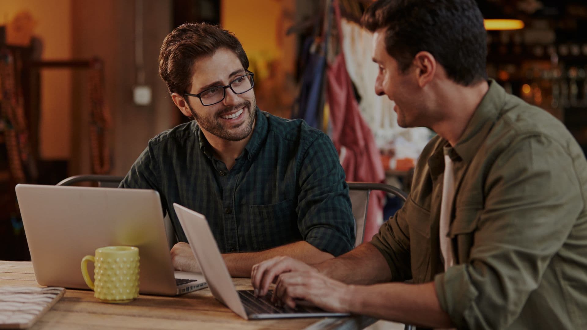 North Star SaaS Provider, two men sharing a clever work insight with laptops in front of them