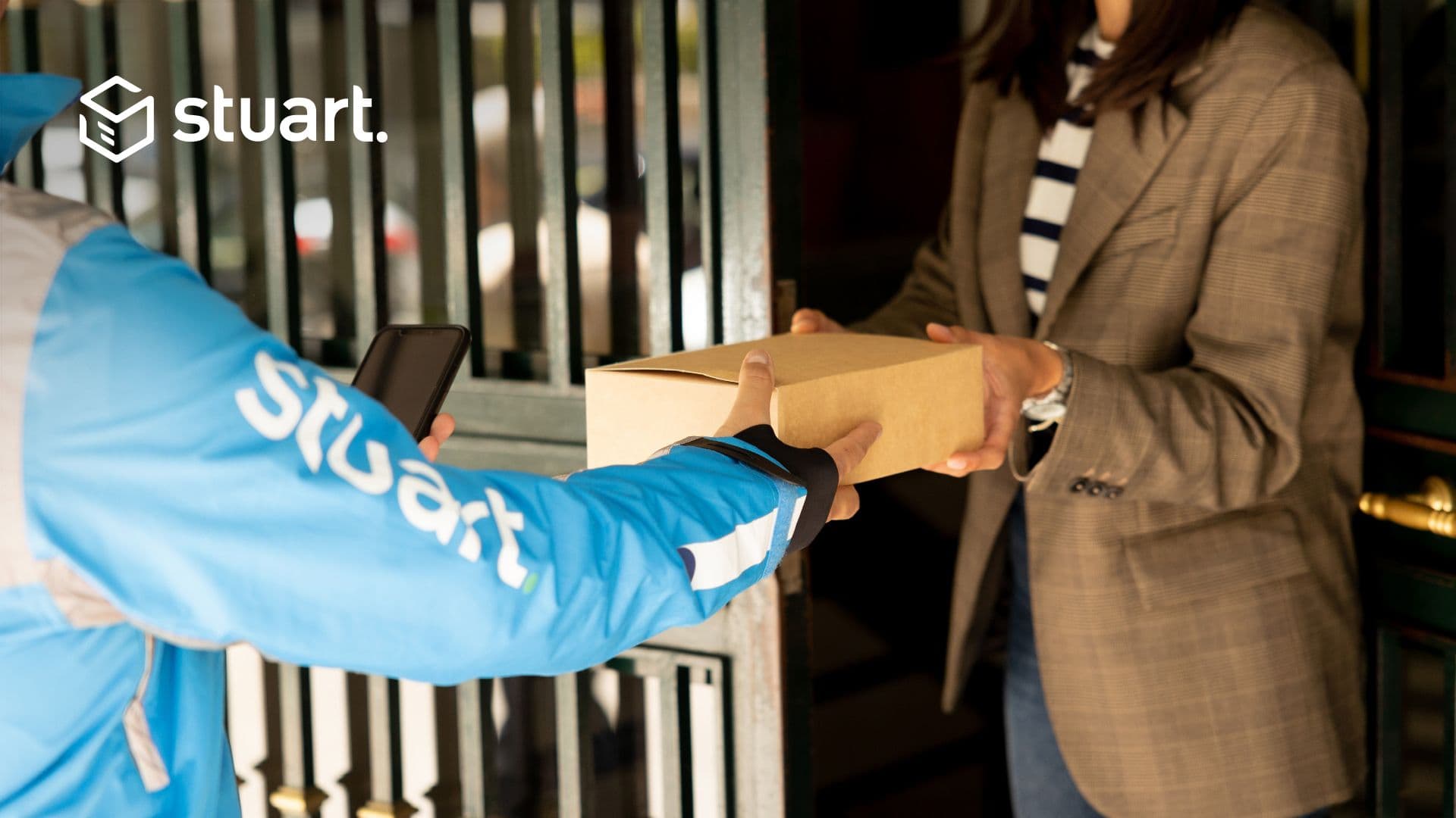 Stuart Courier Handing Delivery Package to Woman