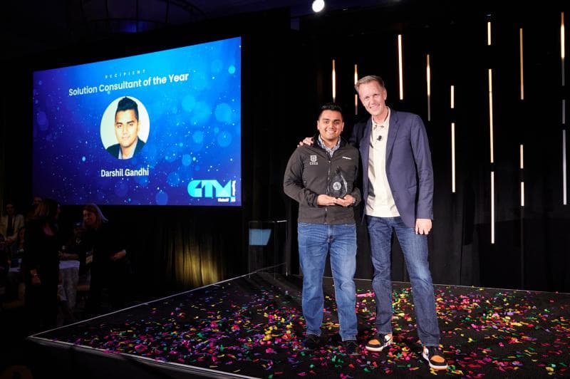 Darshil Gandhi stands next to Amplitude president Thomas Hansen accepting his award for 2022 Solutions Consultant of the Year